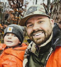 Adam Miller outdoors with his child